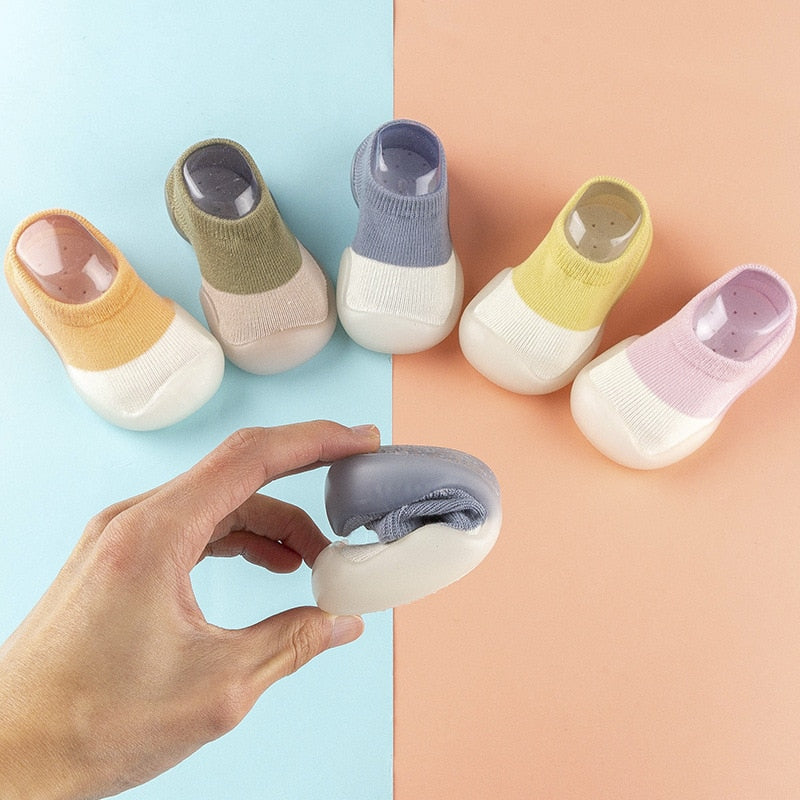 Baby i SweetFeet barfottøfler som krabber på gulvet