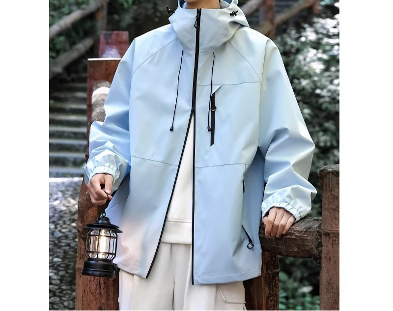 "Winddichte Damen-Regenjacke mit Kapuze in Hellblau, stilvoll und funktional, Seitenansicht für moderne Outdoor-Abenteuer."