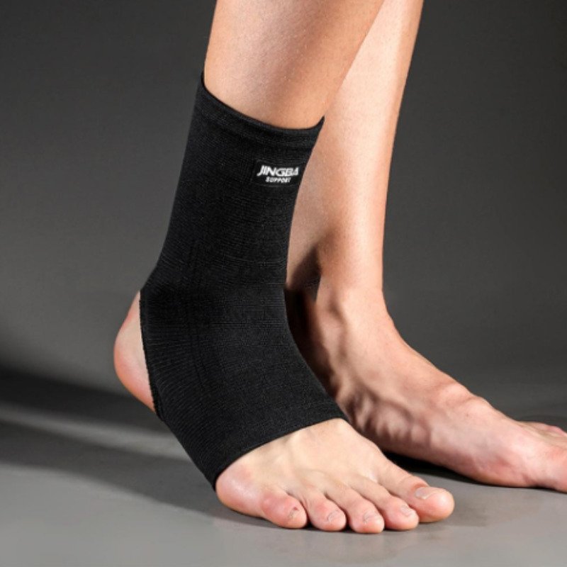 Knöchel-Kompressionsstütze in Schwarz mit elastischem Material, ideal für Sport und Alltag, bietet Stabilität und Komfort.
